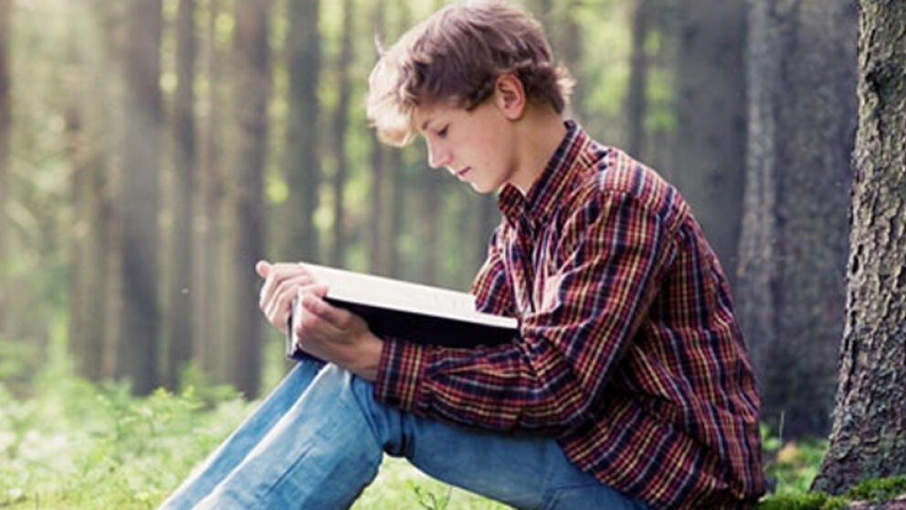 Подросток читает книгу